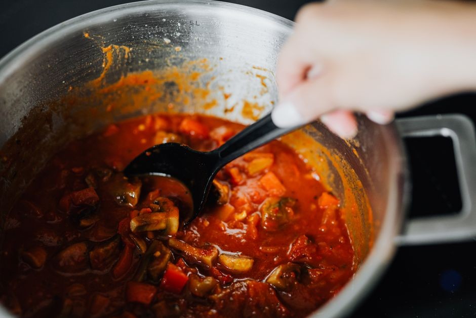 Bahan masakan asam seperti tomat dan sayur yang dimasak mendidih di dalam panci