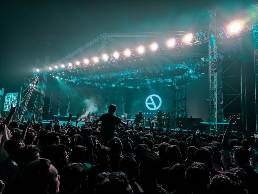 Suasana panggung konser musik dengan tata cahaya megah dan dentuman pengeras suara bervolume tinggi
