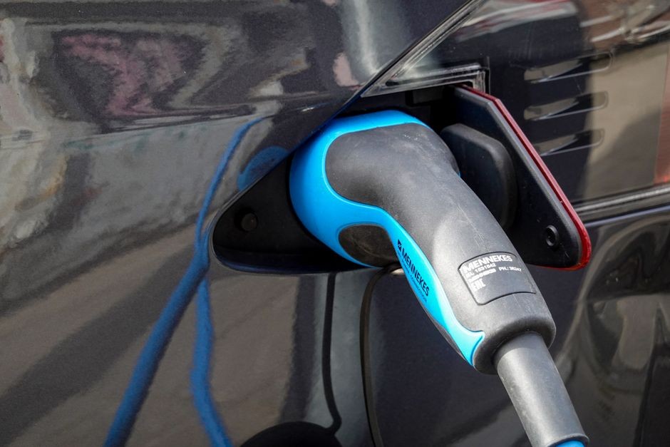HP sedang diisi daya dengan kabel colokan terhubung ke pengisi daya dinding