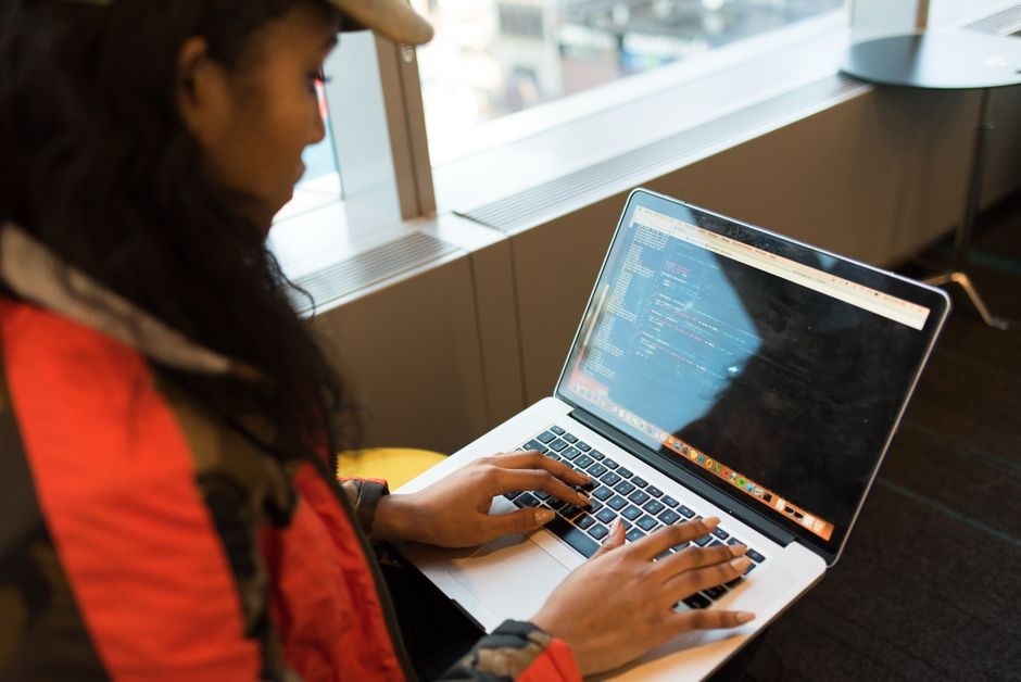 Pengembang sedang menulis kode di laptop untuk mengembangkan aplikasi AI