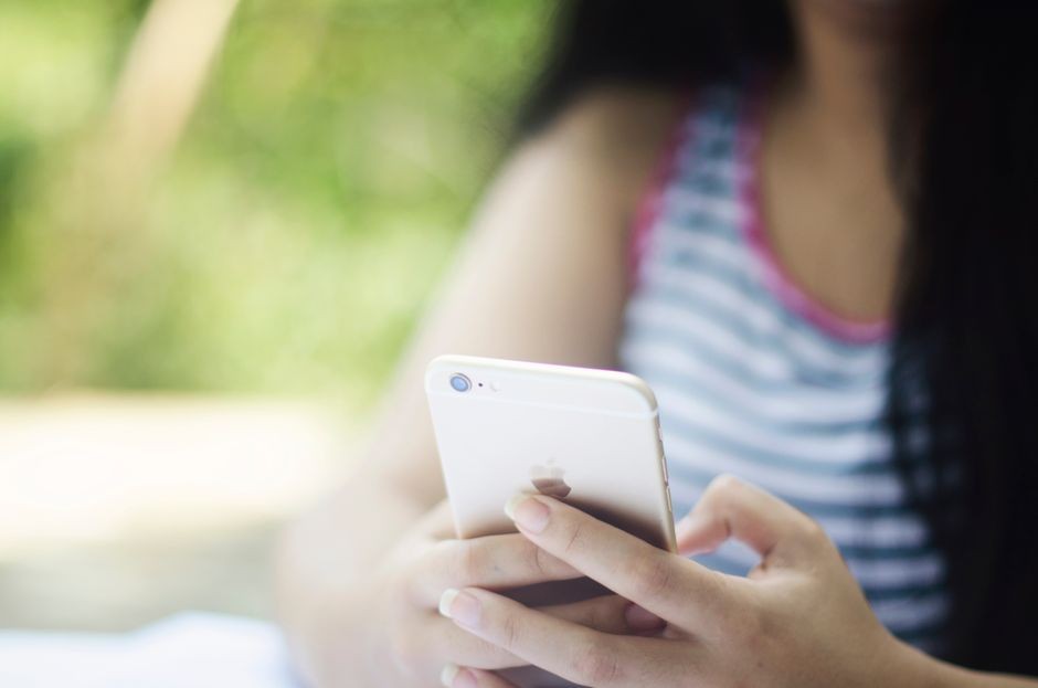 Seseorang menggunakan smartphone di jaringan Wi-Fi publik, momen di mana permintaan DNS rawan disadap