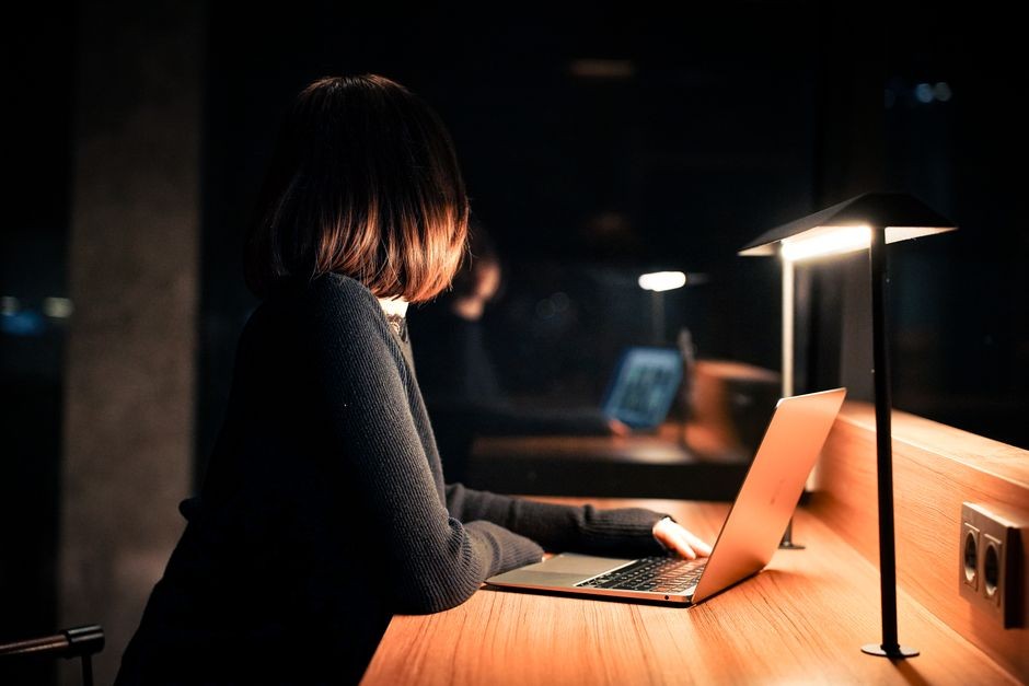 Seseorang bekerja dengan tenang di depan laptop tanpa terganggu dering ponsel di ruang kerja
