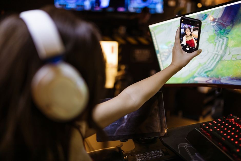 Ilustrasi orang bermain game di ponsel dengan layar menampilkan grafis tajam