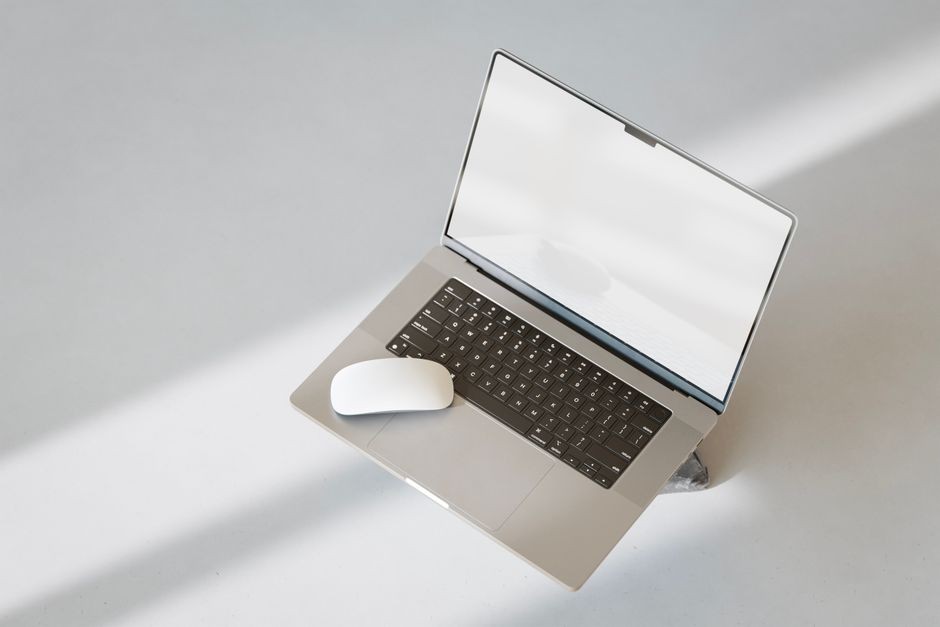 Ilustrasi laptop tipis terbuka di meja kerja dengan layar menampilkan dasbor performa sistem