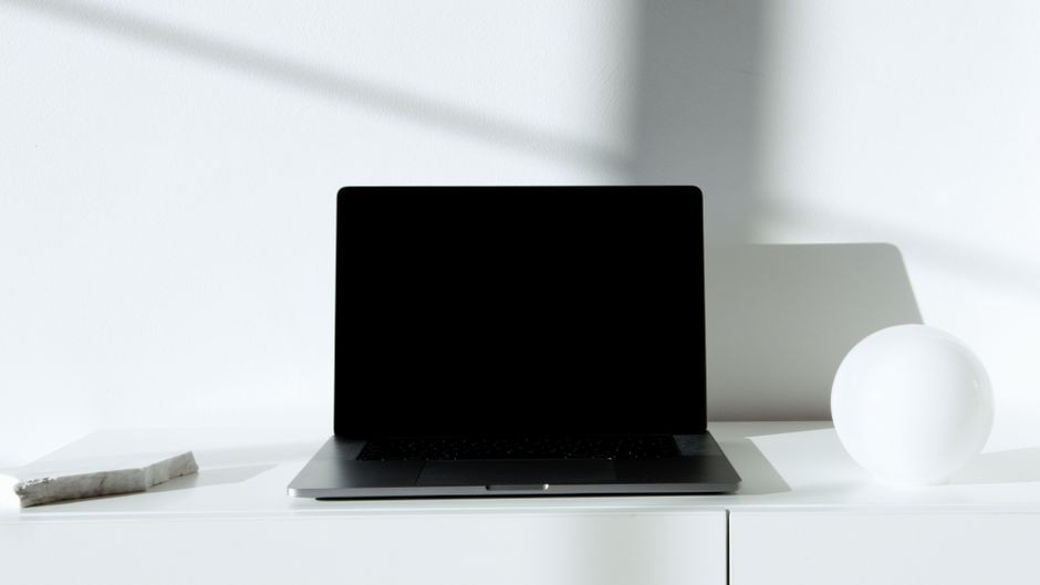 Meja kerja bersih dengan laptop terbuka dan cangkir kopi saat sesi fokus mendalam