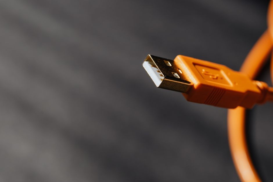 Kabel USB tersambung ke port ponsel untuk transfer file foto dan video secara manual.