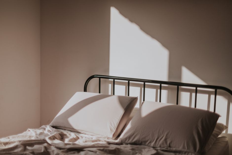 Ilustrasi kamar tidur dengan seprai putih bersih dan cahaya pagi, simbol kebersihan tempat tidur
