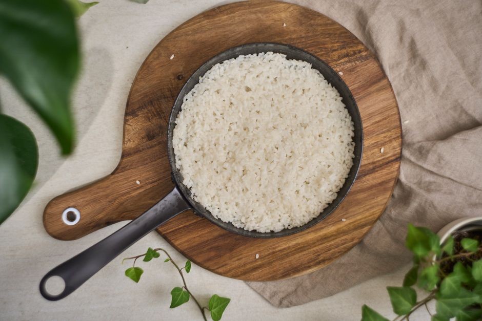 Semangkuk nasi putih matang di meja kayu dapur
