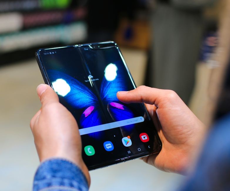 HP lipat modern dengan layar fleksibel terbuka menampilkan antarmuka