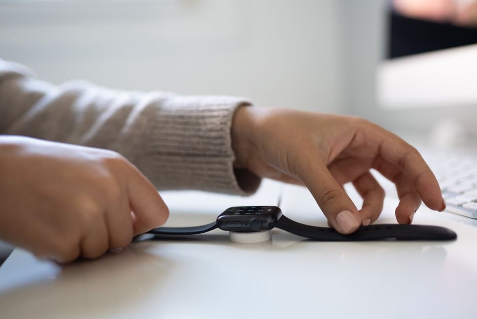 Smartwatch sedang diisi daya di dock pengisi magnetik