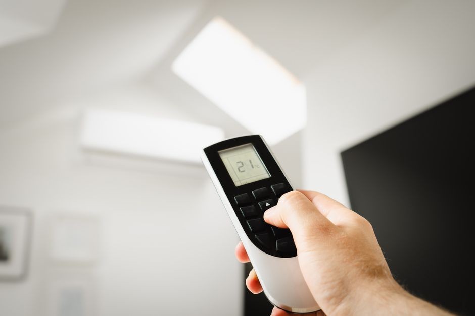 Remote AC menunjukkan pengaturan suhu di dinding ruangan