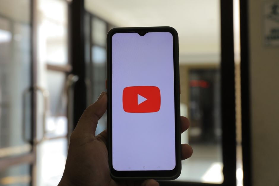 Layar HP memutar video YouTube dengan tombol download di bawah pemutar video