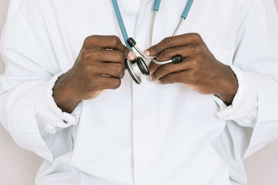 Dokter memeriksa pasien dengan stetoskop di klinik