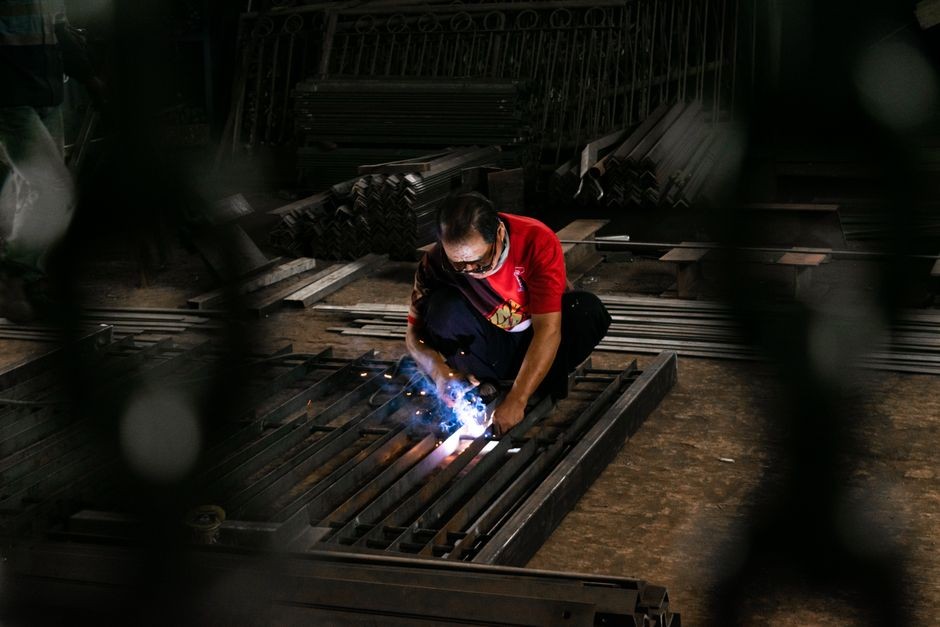 Tangan memegang HP dalam ruangan gelap, dan lampu senter menjadi satu-satunya sumber cahaya
