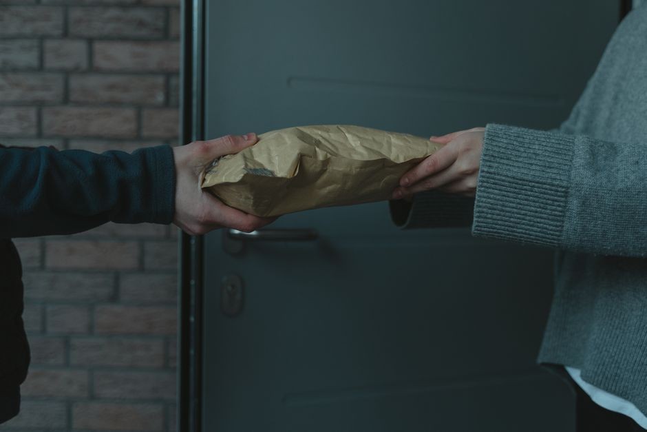 Pembeli memeriksa dan menandatangani penerimaan paket dari kurir