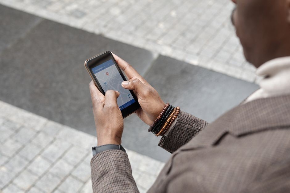 Layar ponsel memperlihatkan aplikasi peta digital dengan rute perjalanan