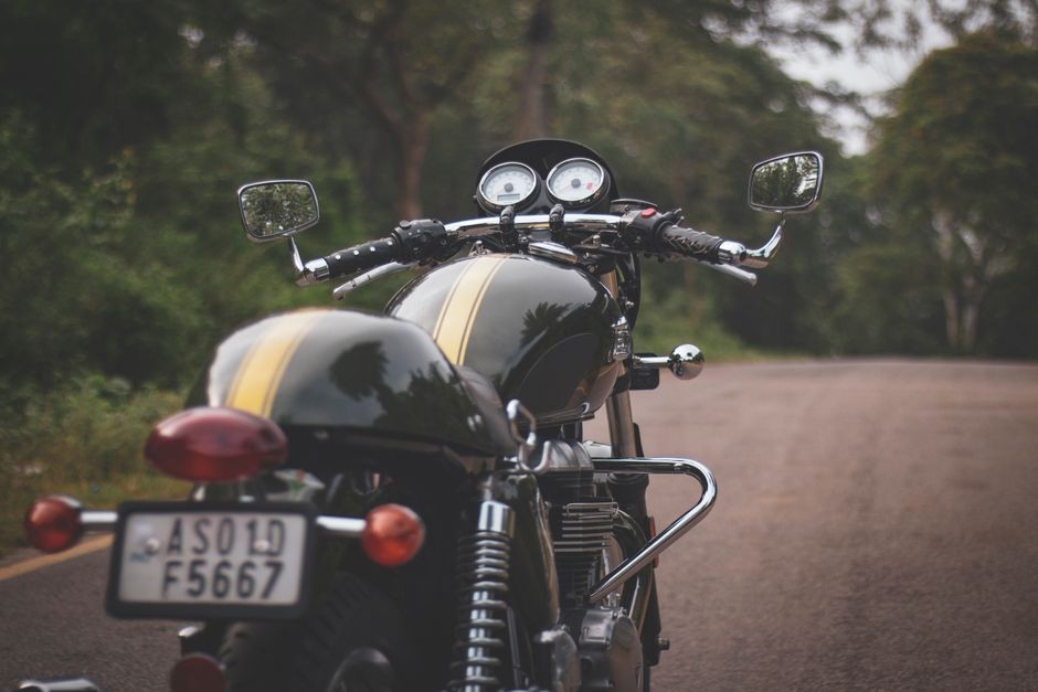 Pengendara sepeda motor mengerem di jalan raya perkotaan yang padat
