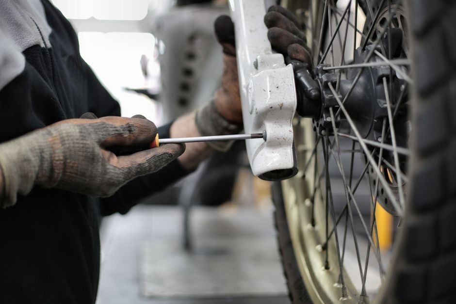 Tukang tambal ban membuka velg untuk memeriksa lapisan dalam ban tubeless, karena kerusakan dari dalam tidak terlihat dari luar.