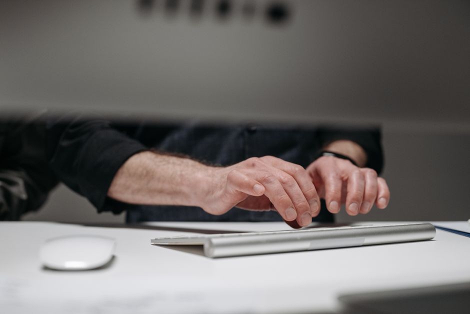 Aktivitas mengetik dokumen kerja secara intensif pada keyboard komputer di ruang kerja