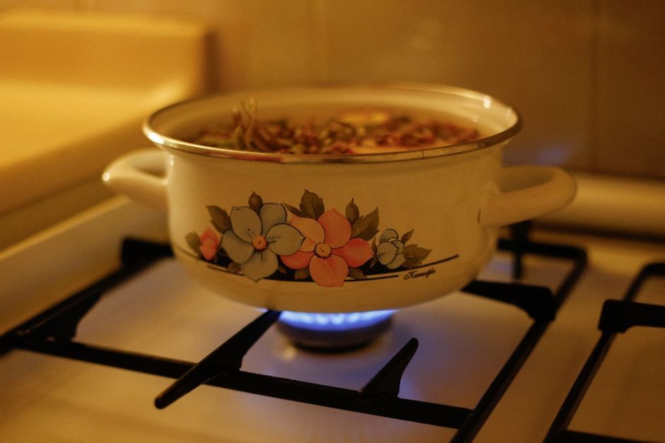 Panci berisi air panas mengepulkan uap hangat untuk perawatan dapur