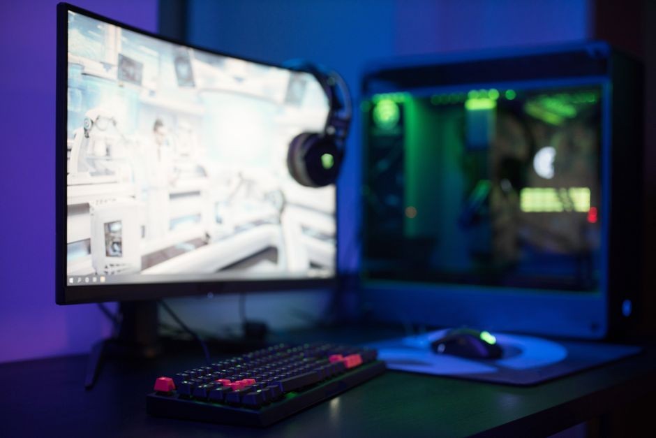 Gamer bermain game aksi kompetitif di depan layar komputer dengan refresh rate tinggi