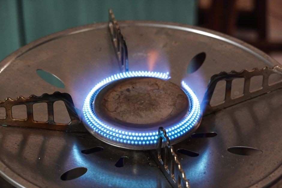 Tungku burner kompor gas menyala dengan nyala api di area dapur rumah