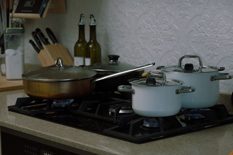 Peralatan panci masak dan wajan penggorengan di atas kompor dapur bersih