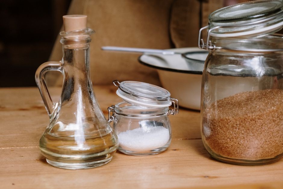Bahan pembersih alami cuka putih dan mangkuk soda kue untuk perawatan serat kain