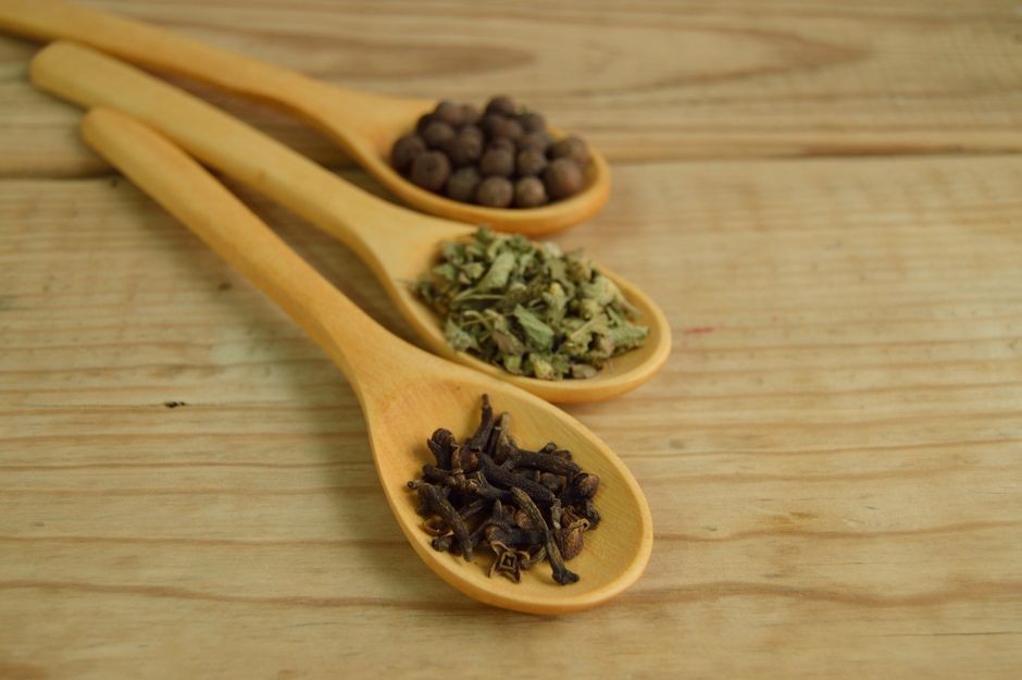 Rempah dapur kering dan daun aromatik alami di atas meja dapur