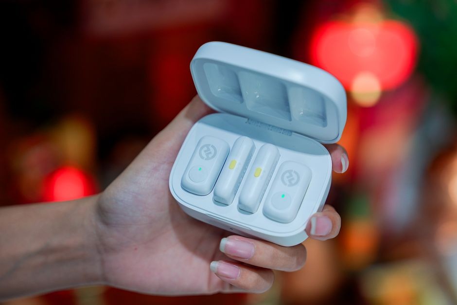 Earbuds nirkabel beserta casing pengisian daya di atas meja