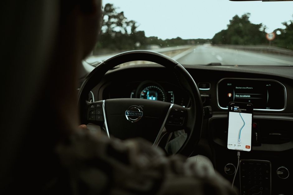 Ilustrasi navigasi GPS smartphone di dashboard mobil yang menguras baterai
