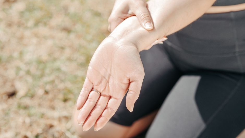 Seseorang menggosok dan mengibaskan tangan untuk meredakan kesemutan