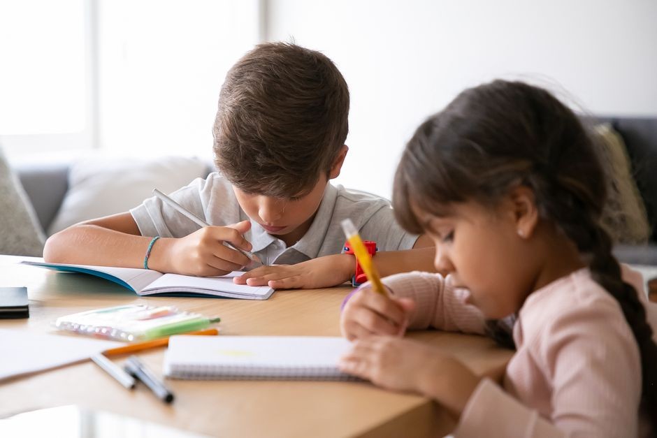 Buku tulis dan alat tulis anak tergeletak di meja belajar