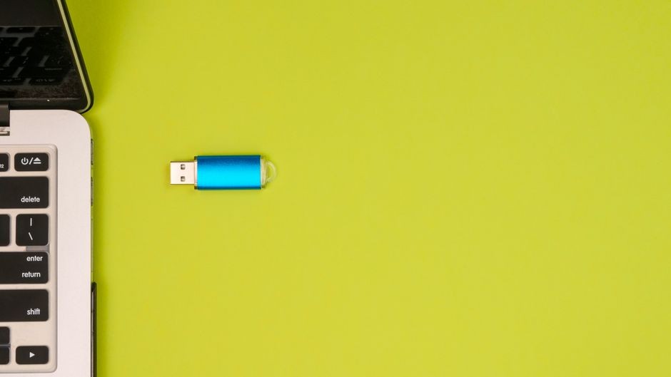 Ilustrasi flashdisk USB tertancap di laptop saat proses transfer data dokumen