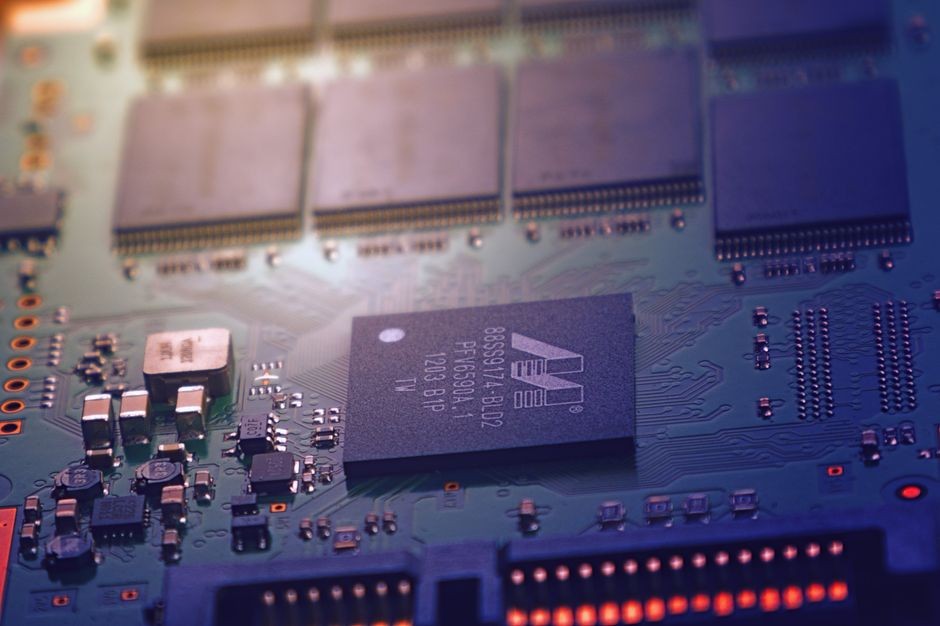 Gambar mendetail dari papan sirkuit elektronik yang menunjukkan mikrocip dan kabel rumit dalam pengaturan teknologi modern.