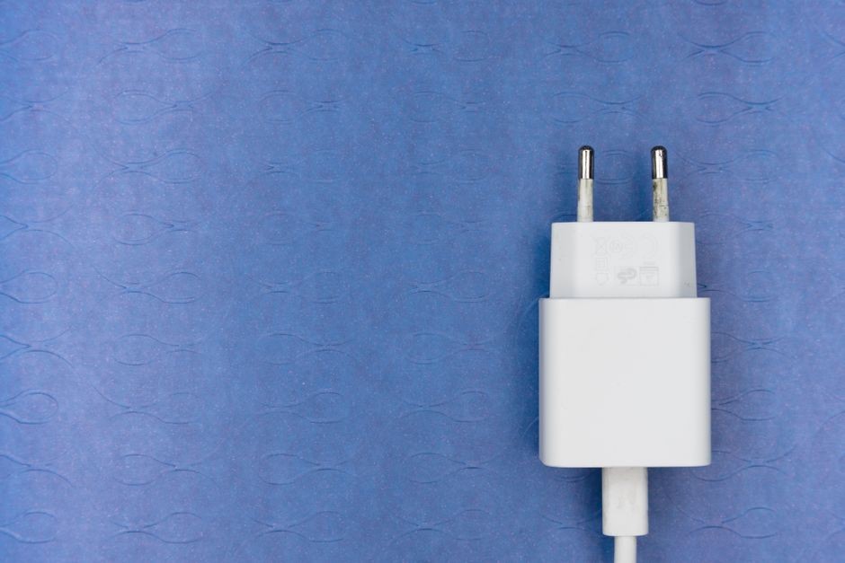 Ilustrasi kabel charger smartphone terhubung rapi di meja kerja
