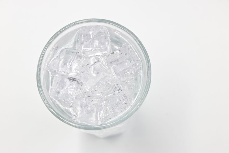 Es batu segar dalam gelas di latar belakang putih, sempurna untuk tema minuman dan gaya hidup.