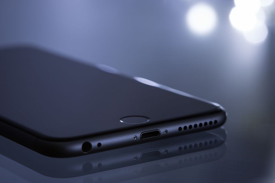 Close-up smartphone ramping dengan refleksi bokeh kabur yang menampilkan desain teknologi modern.