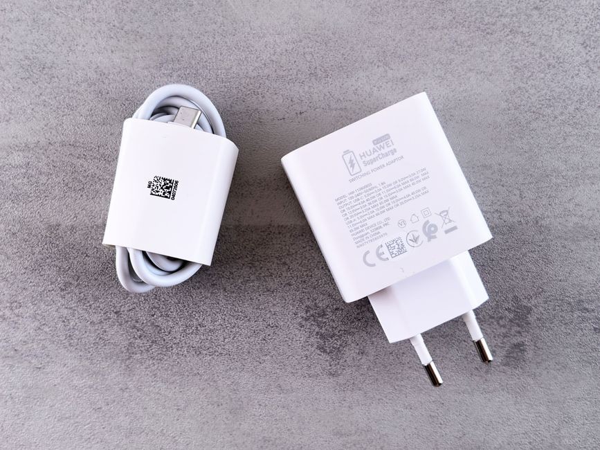 Port pengisian daya smartphone dan kabel charger USB di atas meja