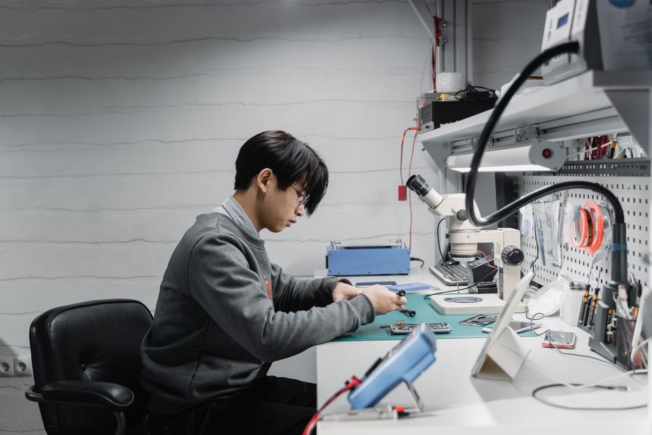Teknisi servis elektronik memeriksa pin dan sirkuit konektor menggunakan alat presisi