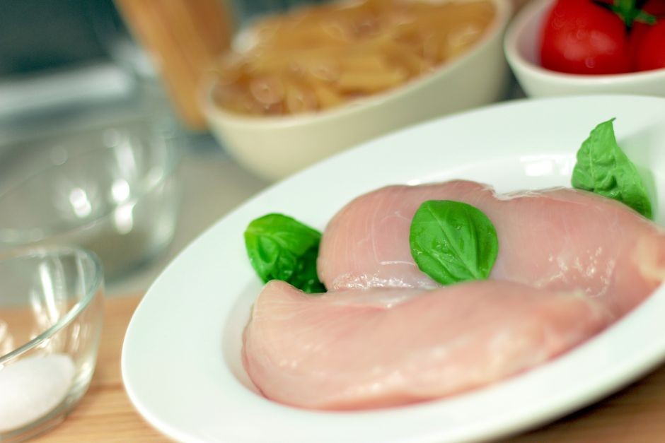 Potongan daging ayam mentah segar di atas piring sebelum dimasak