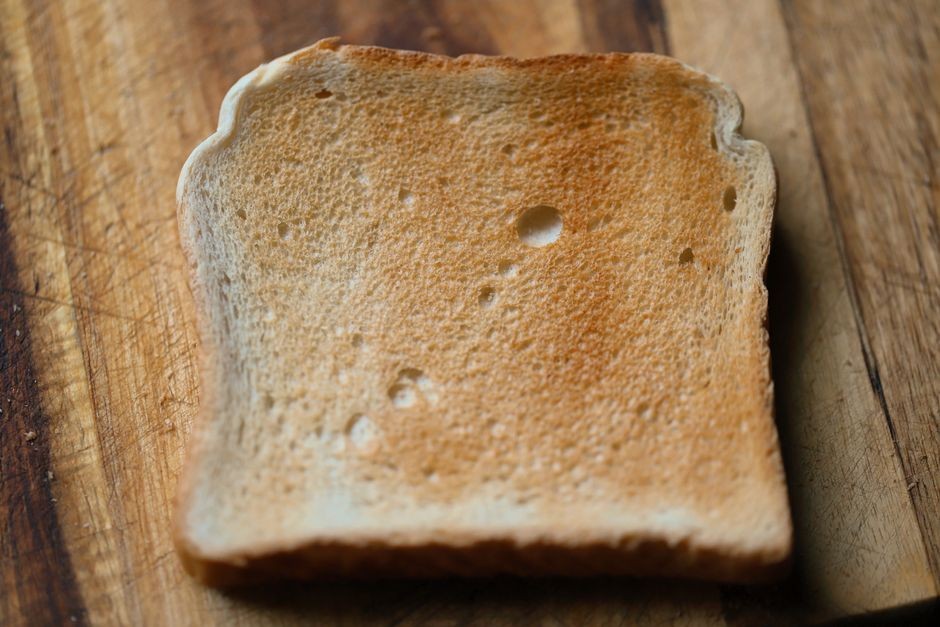 Sepotong roti tawar yang dipanggang renyah di atas pemanggang roti