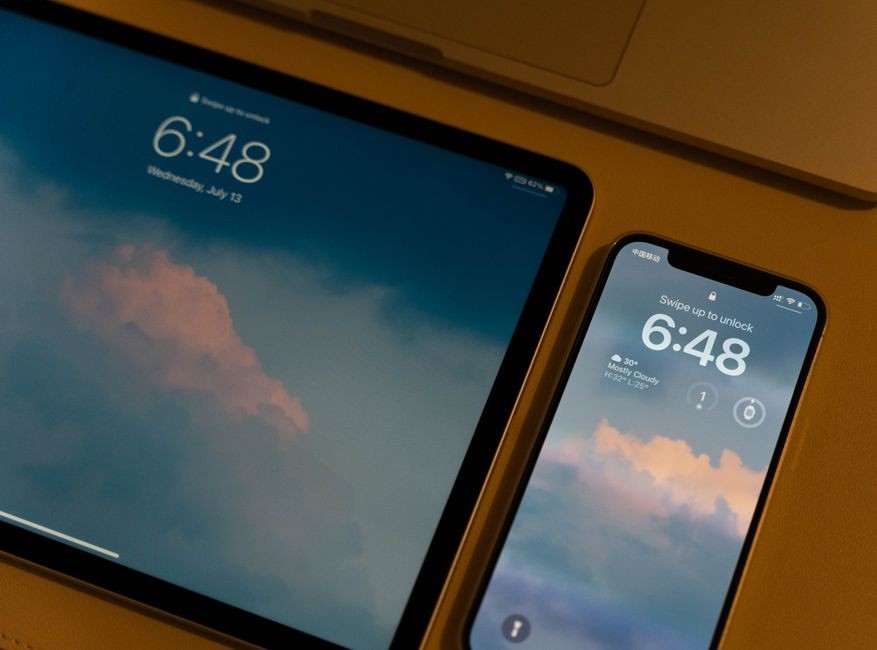 Close-up perangkat digital modern dengan wallpaper bertema awan dan layar kunci.