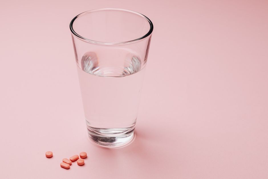 Tablet suplemen vitamin C efervesen yang larut bergelembung di dalam segelas air.