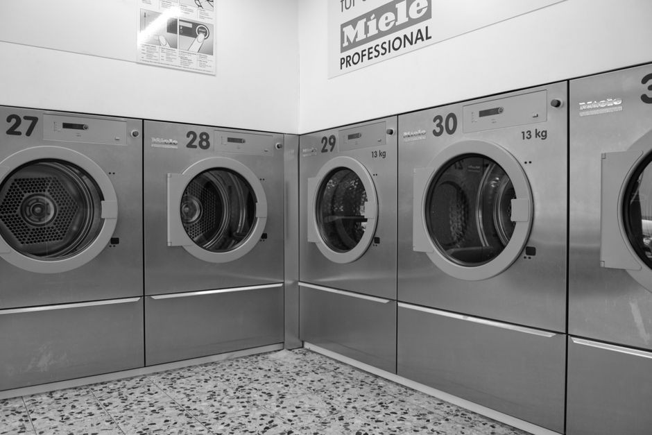 Pintu mesin cuci bukaan depan yang dibiarkan terbuka di ruang laundry