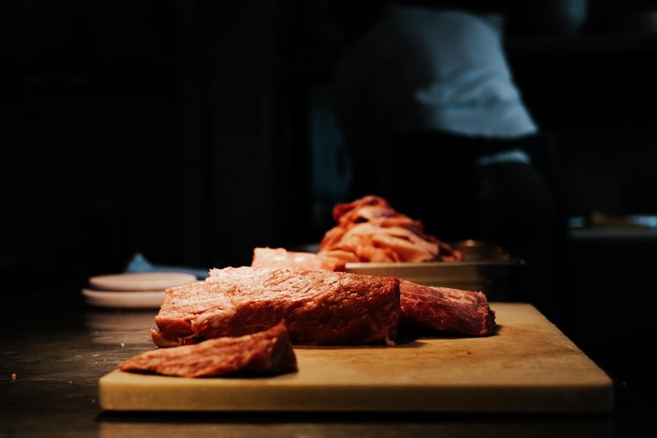 Potongan daging segar di atas talenan dapur siap dimasak