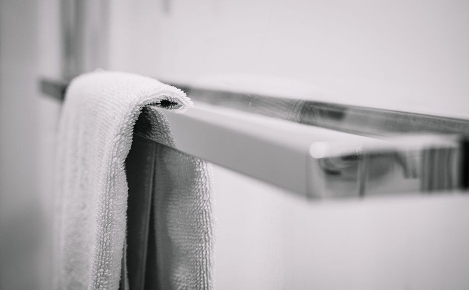 Handuk mandi digantung di dalam kamar mandi yang lembap