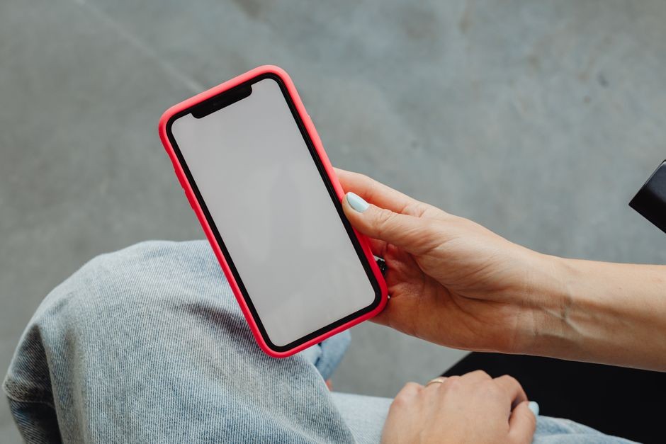 Pengguna memegang smartphone secara horizontal saat bermain game atau memutar video