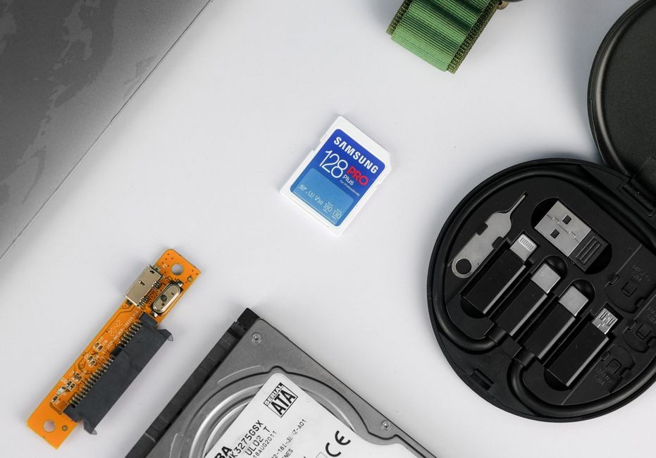 Tata letak datar berbagai komponen teknis termasuk kartu memori dan hard drive di latar belakang putih.