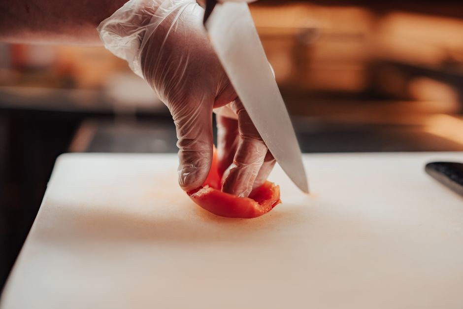 Aktivitas memotong bahan makanan dengan pisau dapur di atas talenan